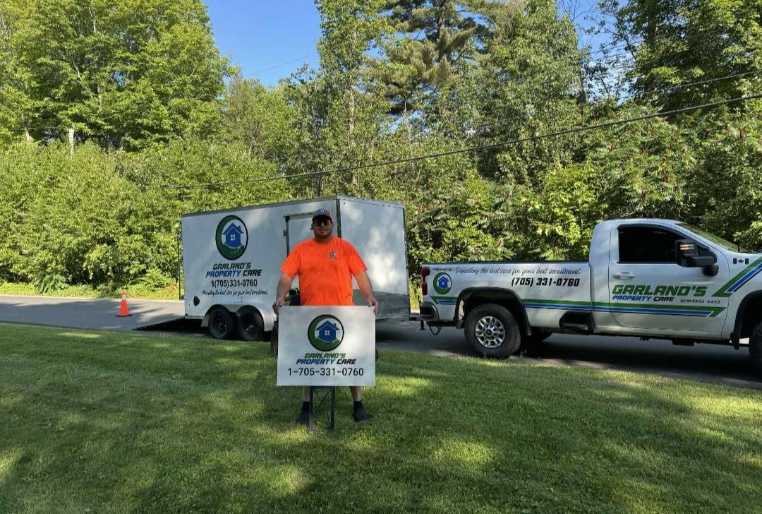 Lucas Garland with branded lawn sign, truck, and trailer